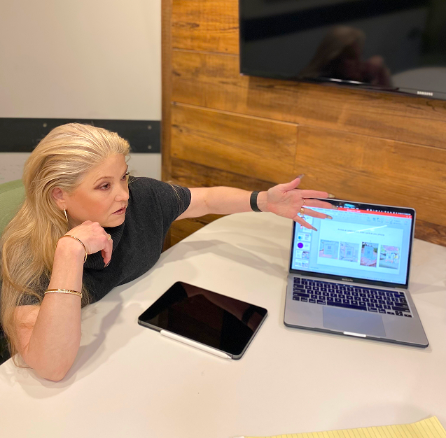 ECF Founder Nancy Dibert conducting a mentoring session, pointing to a presentation on a laptop screen.